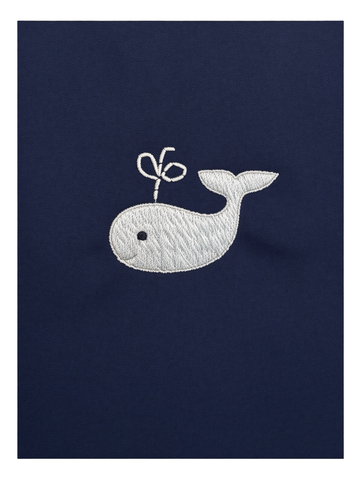 Detail of the hand-embroidered blue whale on the navy bobby suit
