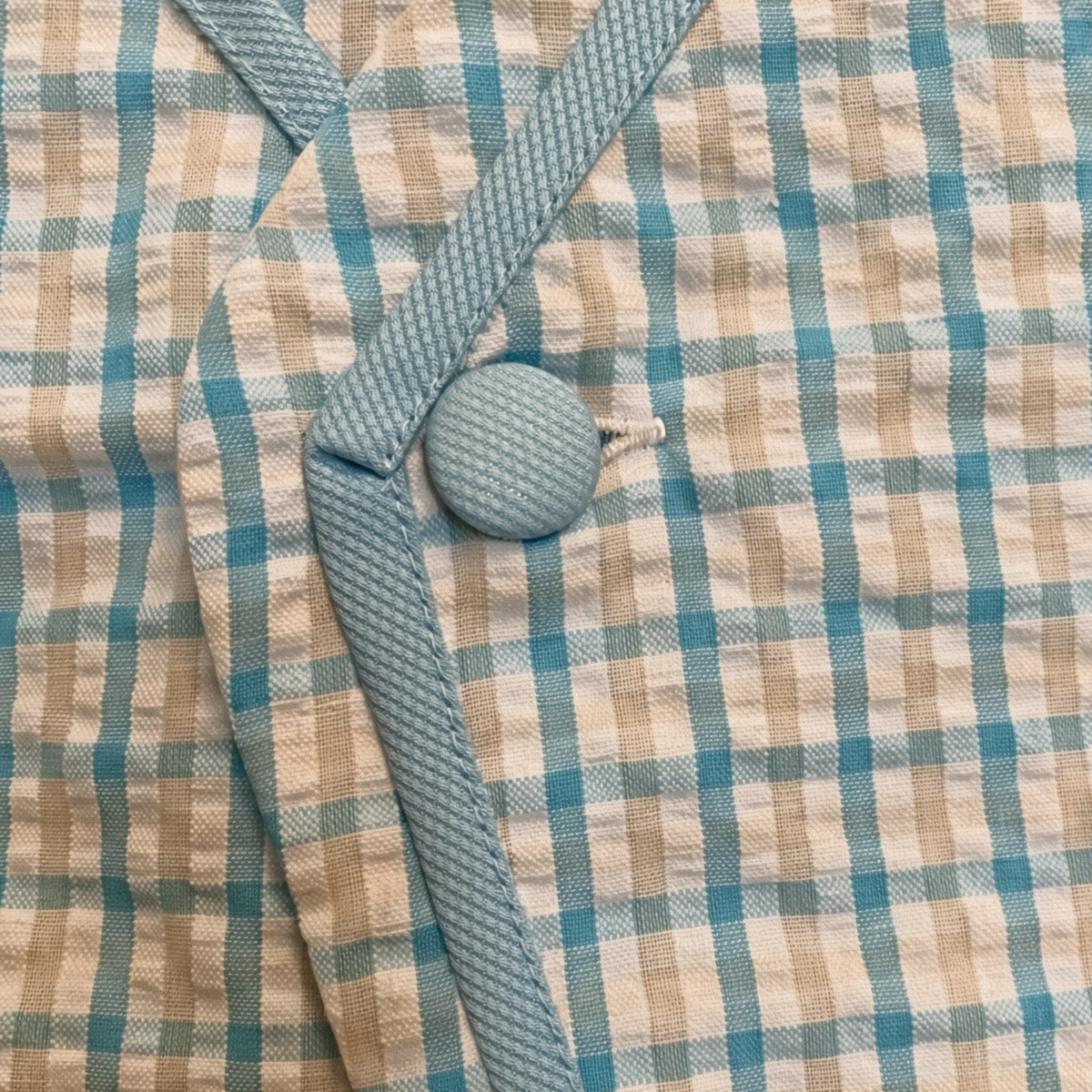 Detail of the covered button and gingham trim on the blue check set