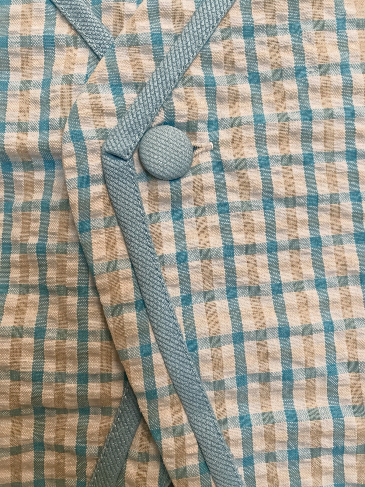 Detail of the covered button and gingham trim on the blue check set