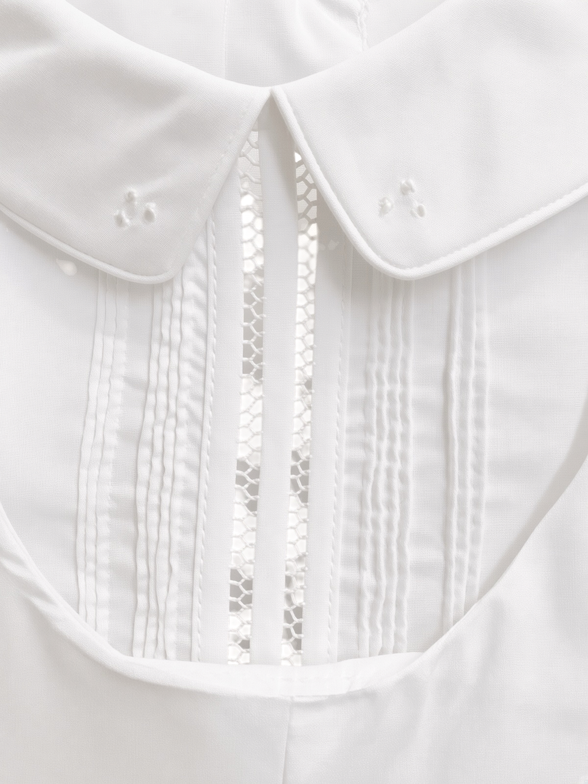 Detail of the embroidered Peter Pan collar, pintucks and lace insertion on the christening shortall