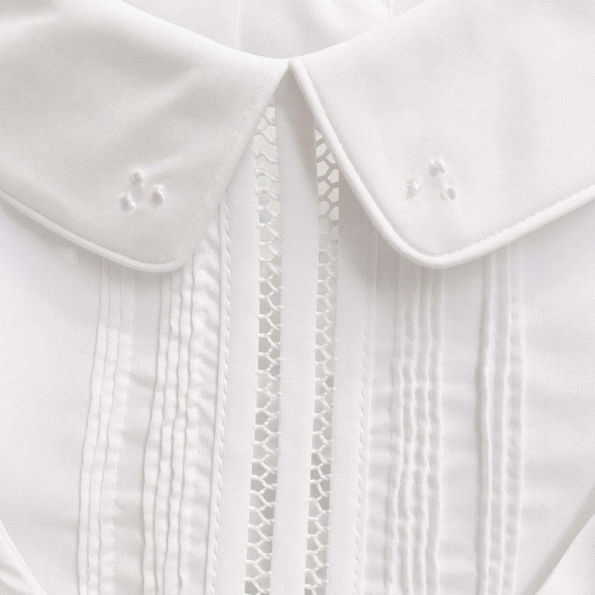 Detail of the embroidered Peter Pan collar, pintucks and lace insertion on the christening shortall