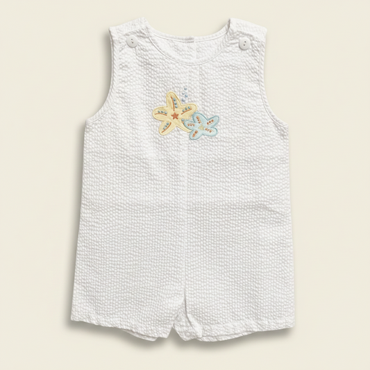 Petit Ami white seersucker bubble with yellow and blue starfish appliqué, front
