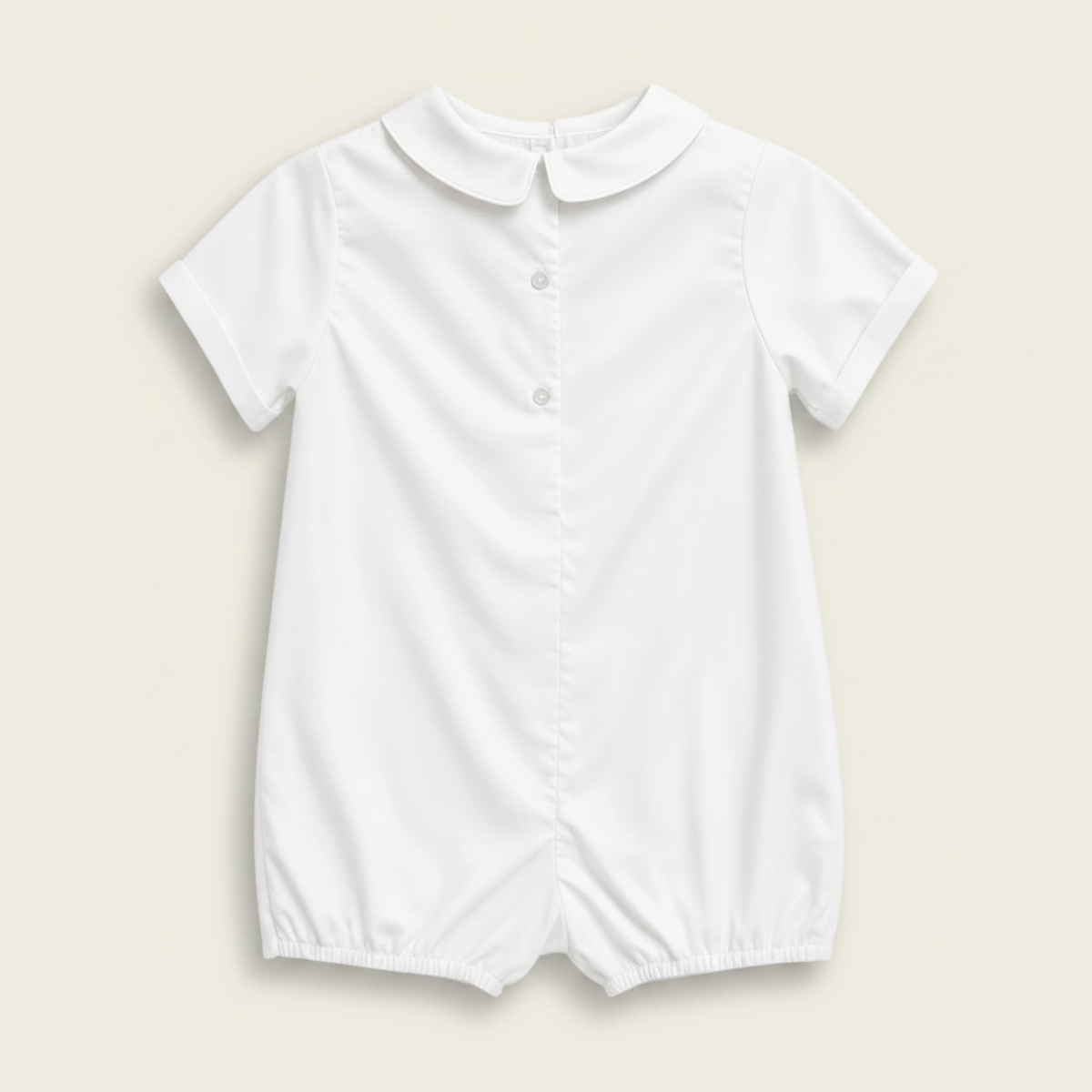 Petit Ami white christening shortall, back, showing the buttoned closure and Peter Pan collar