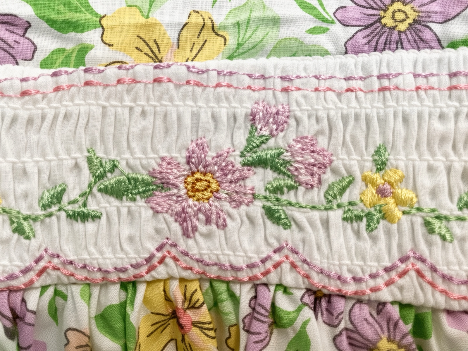Detail of the hand-smocked and embroidered waist band on the floral sundress